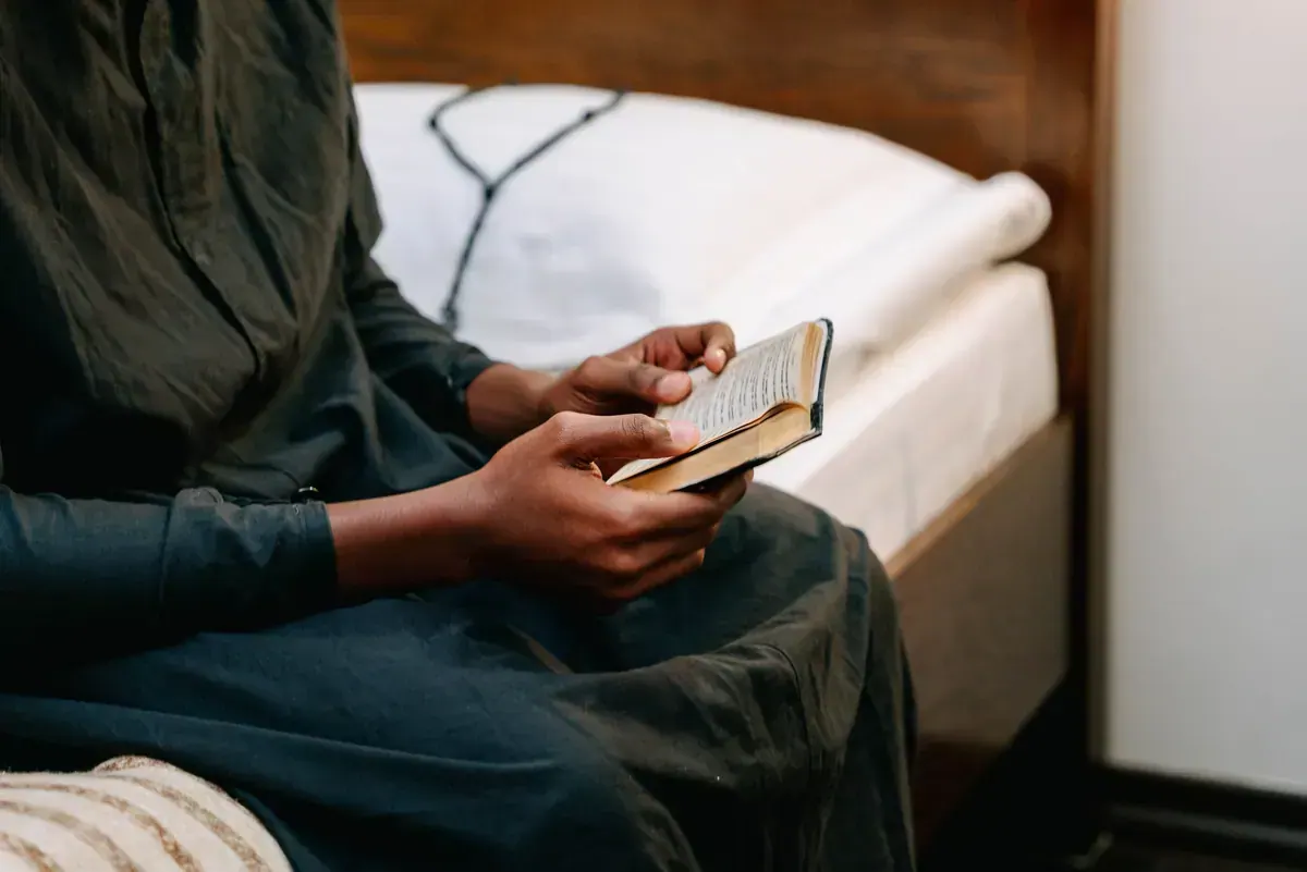 Person holding a Bible while praying for comfort during illness