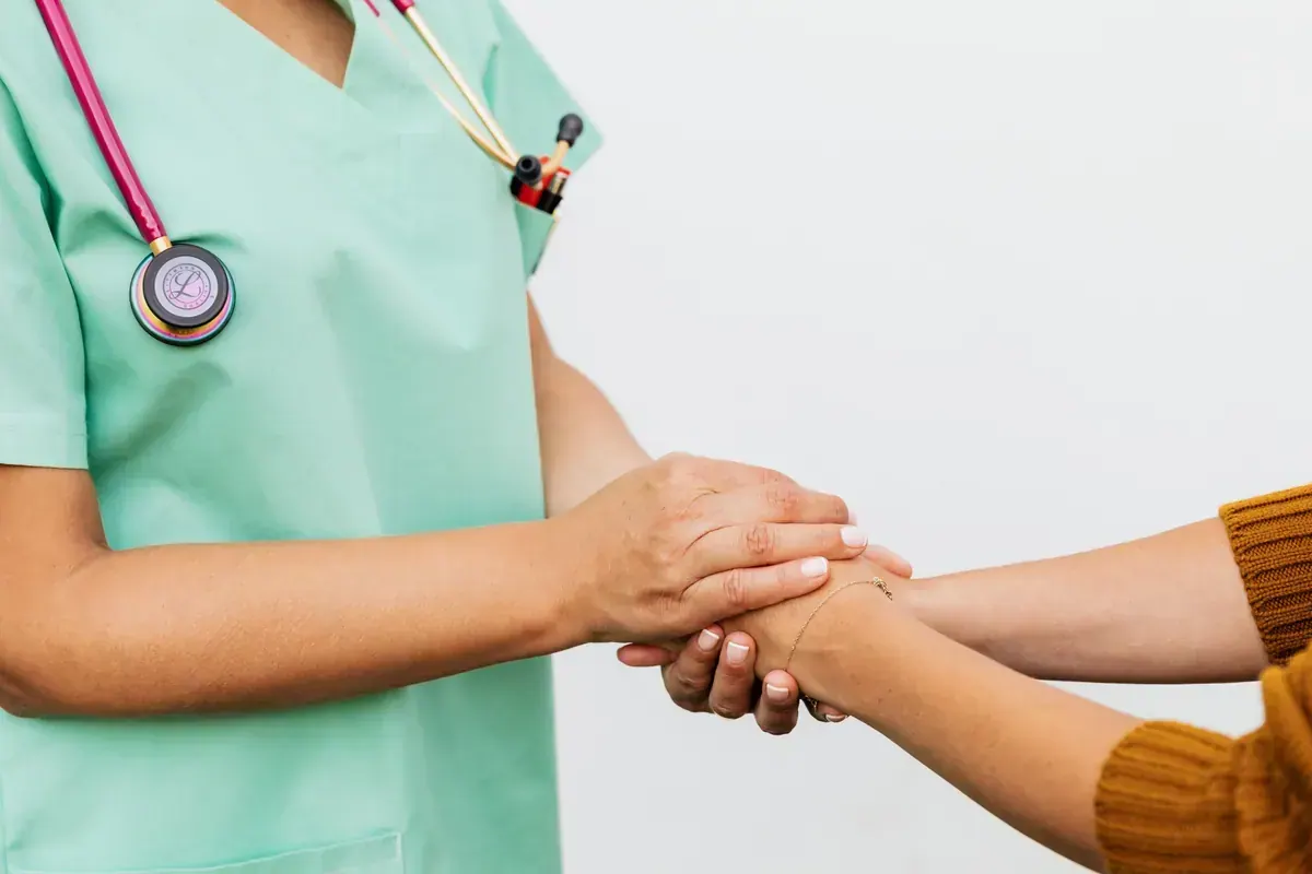 Hands of a healthcare worker comforting and reassuring a patient