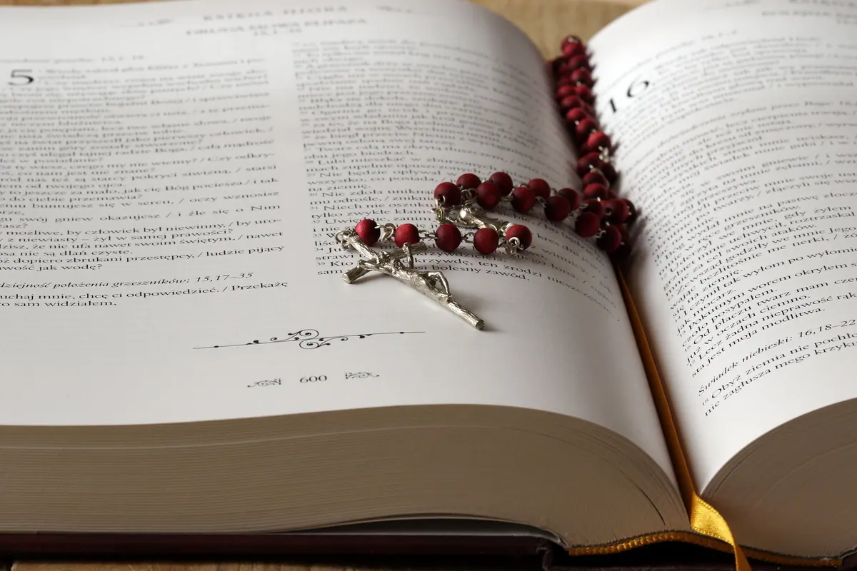 Open Bible with rosary beads for devotional healing prayer